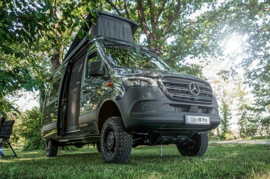 Graues Campingfahrzeug mit aufgestelltem Hochdach und geöffneter Seitenschiebetüre. | © AL-KO VT